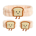 Plush bread toys with smiling faces on a white background
