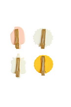 Set of four colorful hair clips on a white background