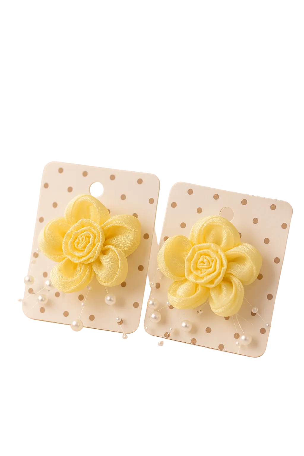 Yellow flower-shaped earrings on polka dot cards with a plant in the background