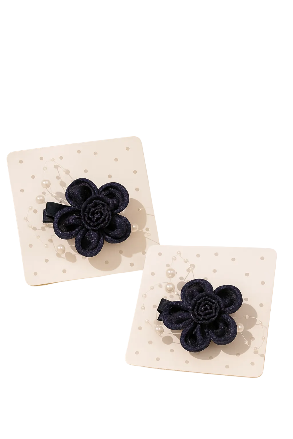 Navy blue flower-shaped hair clips on white cards with a beige background and plant.