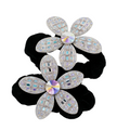 Two black hair ties with silver flower-shaped ends featuring multicolored stones on a white background.