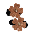 Pair of flower-shaped hair ties with rose gold embellishments on a white background