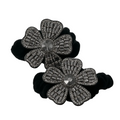 Black flower-shaped hair ties with gemstone details on a white background