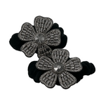 Black flower-shaped hair ties with gemstone details on a white background