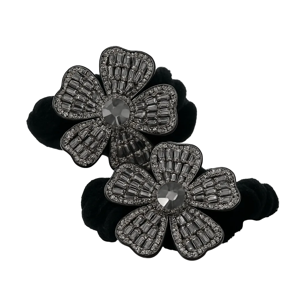 Black flower-shaped hair ties with gemstone details on a white background