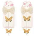 Two butterfly hair clips with decorative bows on packaging featuring cartoon bunny faces.