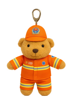 Plush bear toy in an orange fireman uniform with a keychain clip on a white background