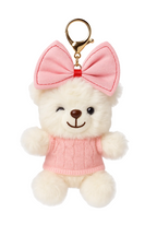 Plush toy bear with a pink bow and sweater on a white background