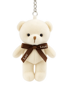 Small cream teddy bear with a brown 'Love' ribbon on a white background