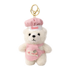 Small teddy bear keychain wearing a pink apron and chef's hat on a white background