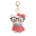 Keychain with a cartoon character wearing glasses and a pink dress on a white background