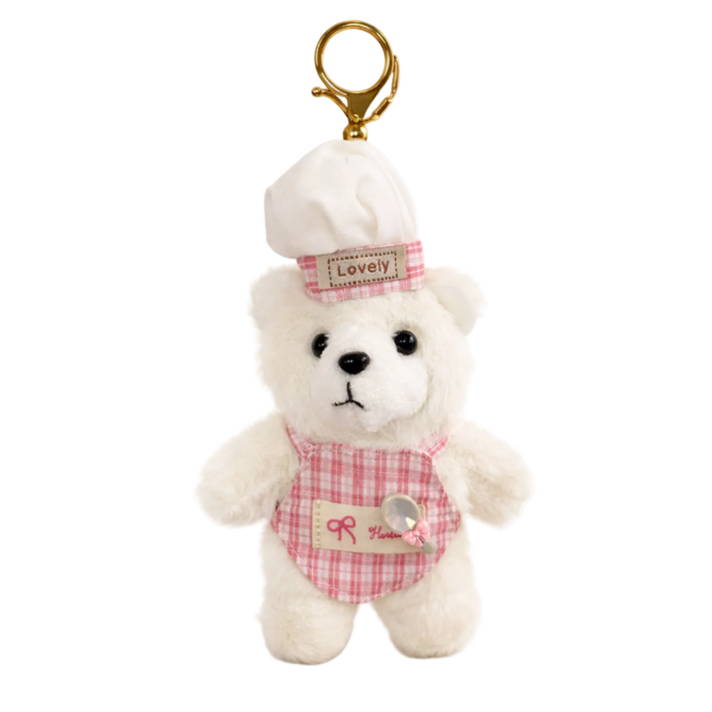 Small white teddy bear keychain with a pink checkered outfit and 'Lovely' hat on a white background