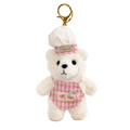 Small white teddy bear keychain with a pink checkered outfit and 'Lovely' hat on a white background